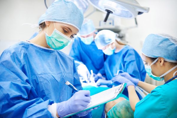File this under “the high price of surgical multi-tasking” 1 surgeon writing down some operation notes